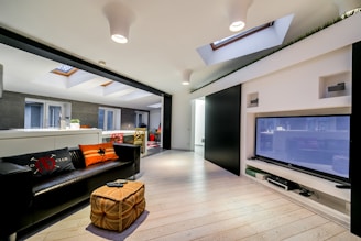 a living room with a black couch and a flat screen tv