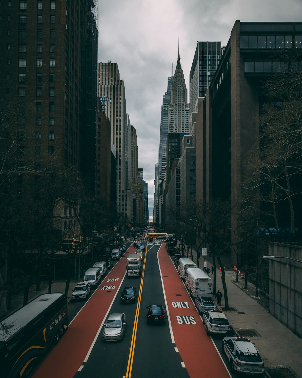 a city street filled with lots of traffic next to tall buildings