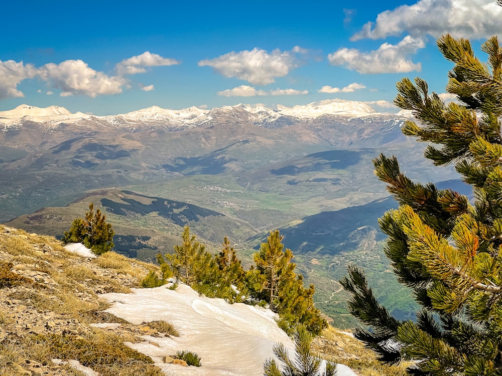 a view of a mountain range with snow on the ground