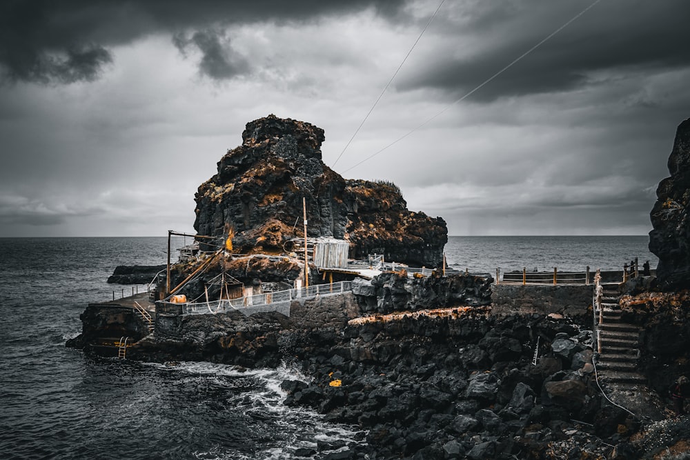 a boat sitting on top of a rocky pier next to the ocean