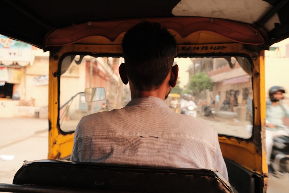 a man driving a tuk tuk down a street