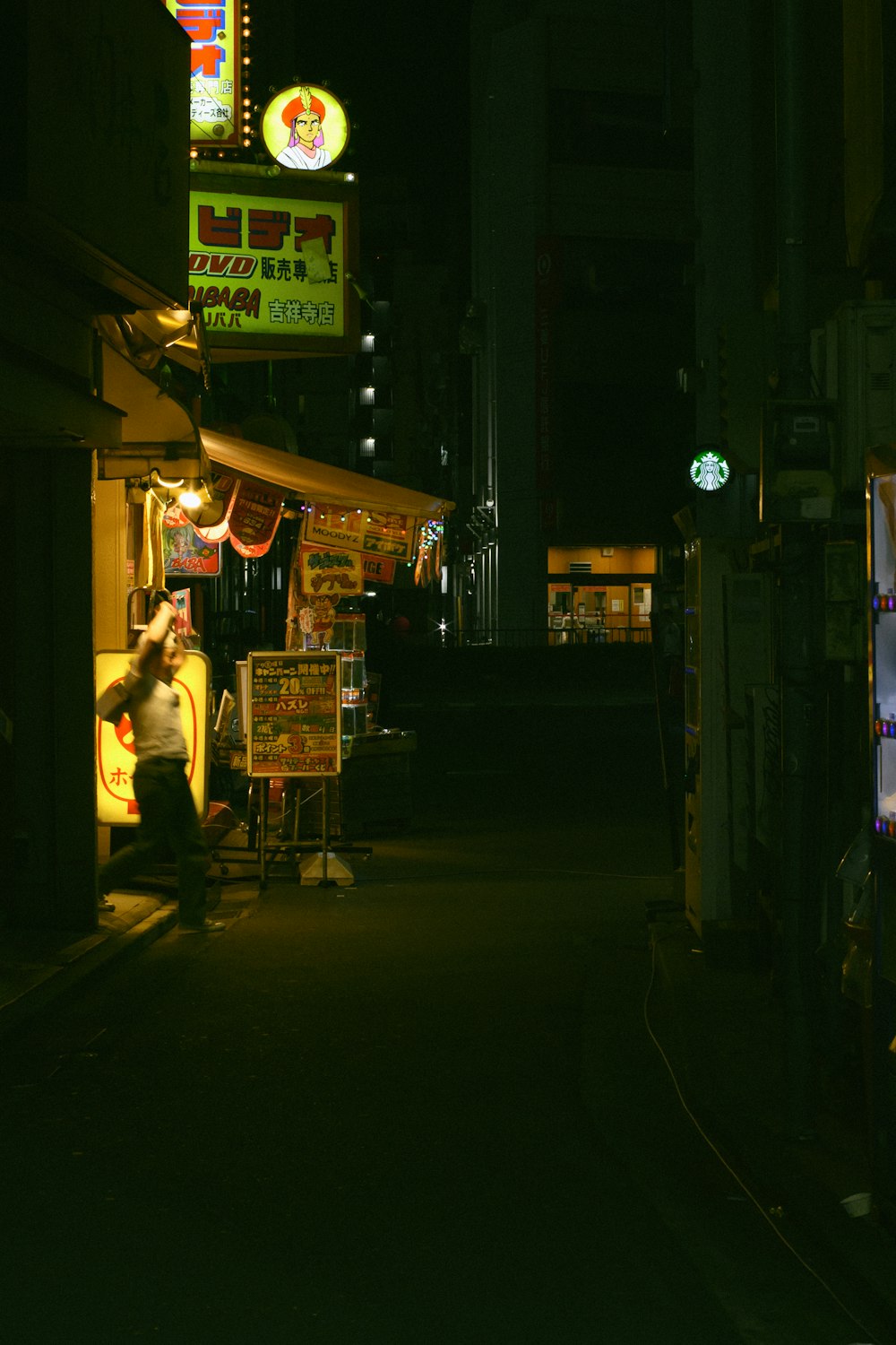 a man sitting in a chair in a dark alley