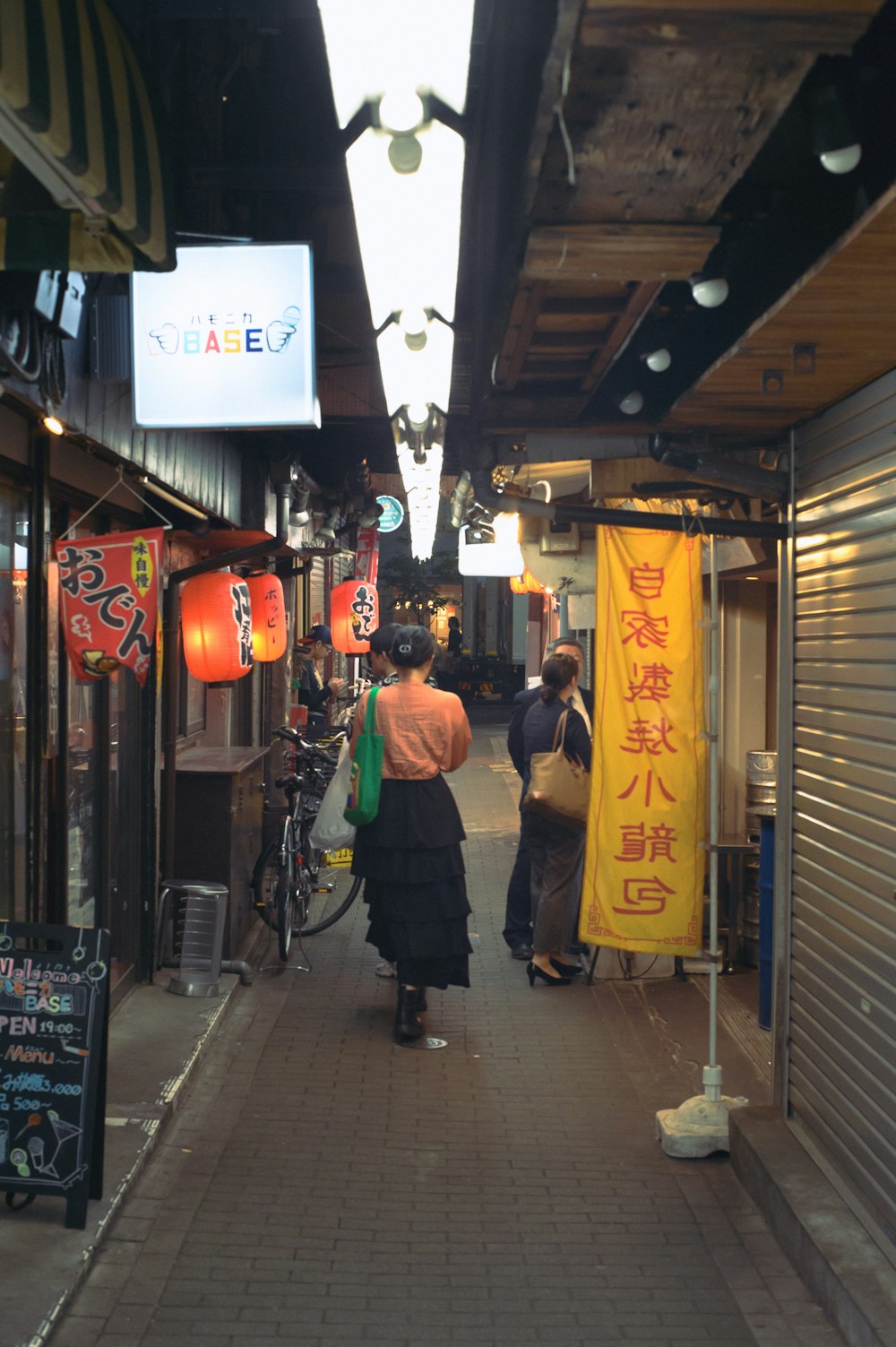 una mujer caminando por una calle al lado de una tienda