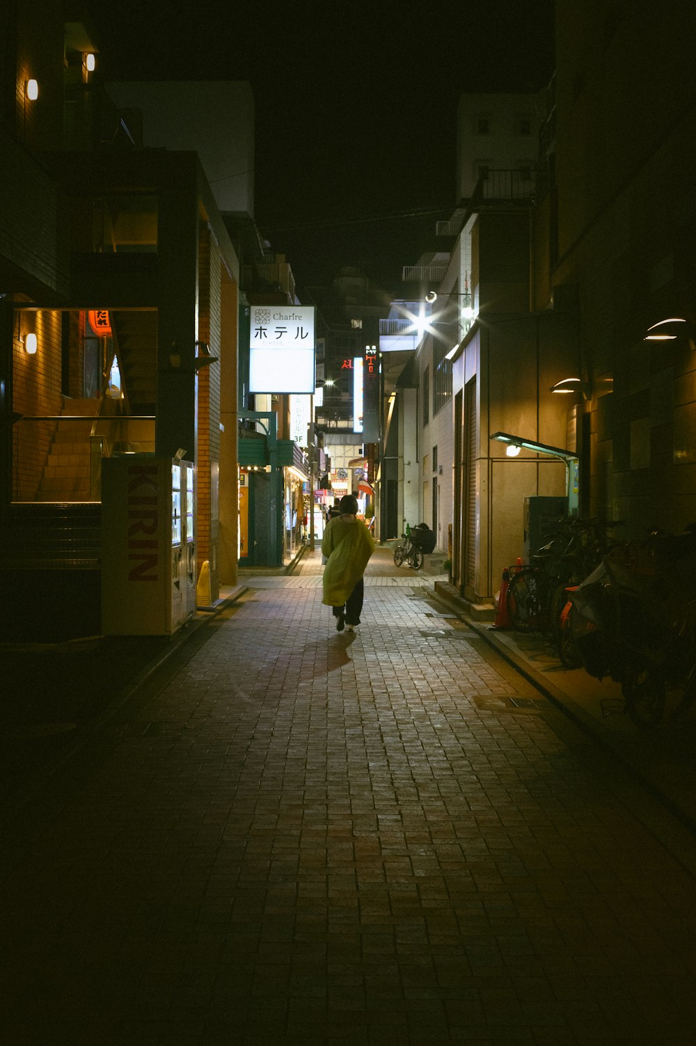 a person walking down a street at night