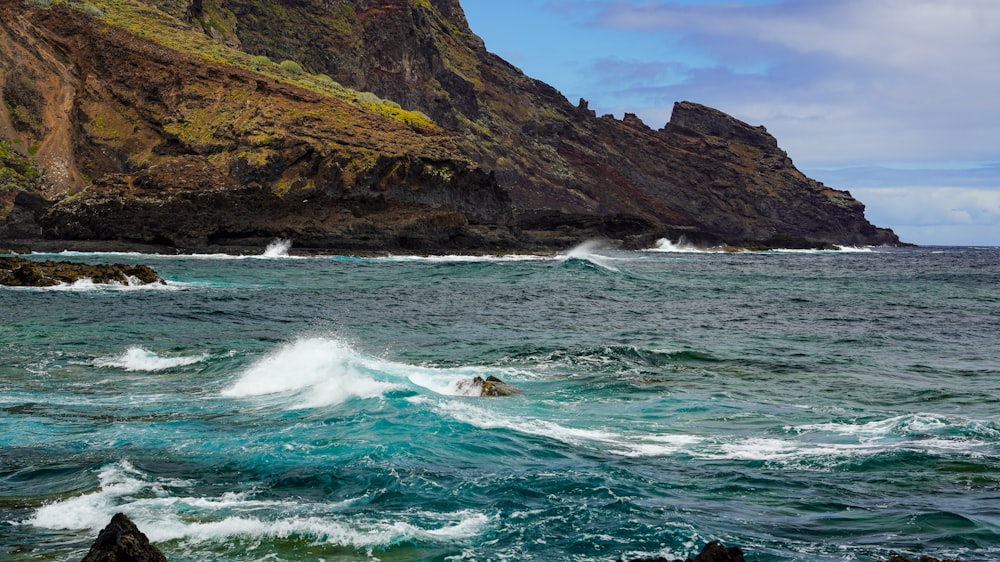 a body of water near a rocky cliff