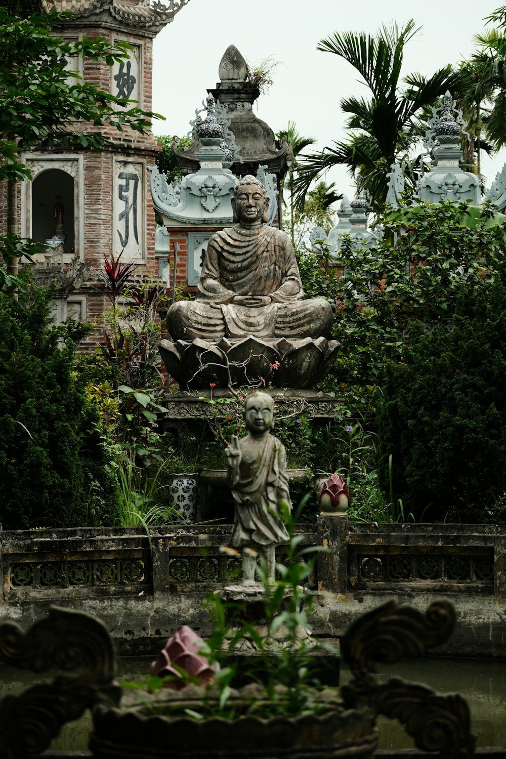 a statue of a person sitting in a garden