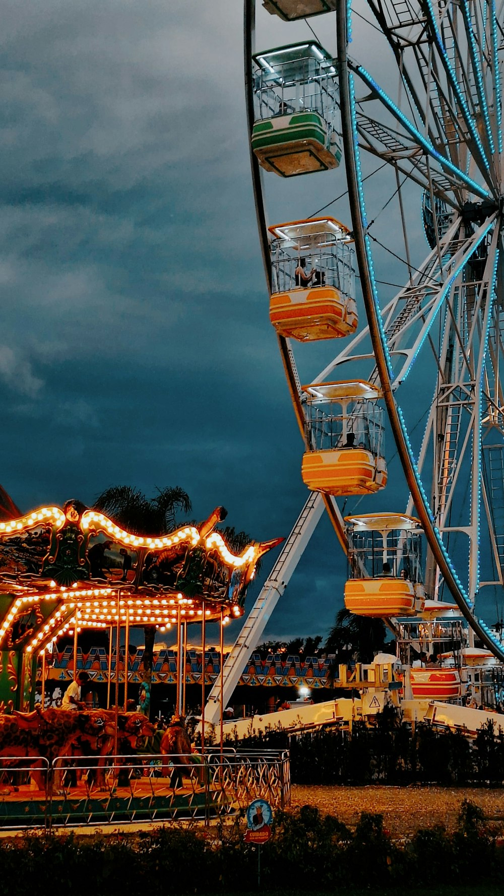 a large ferris wheel sitting next to a carnival ride