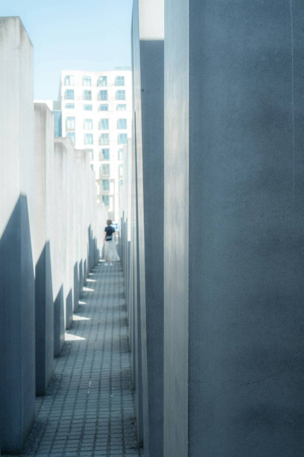 a person walking down a sidewalk next to tall buildings