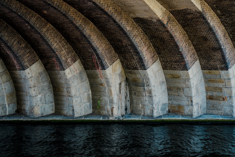 a man riding a surfboard under a bridge