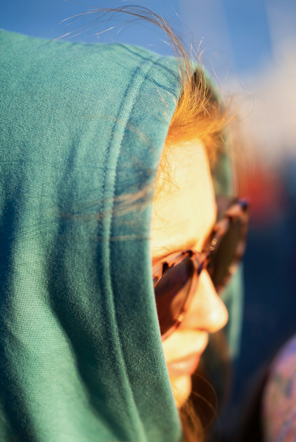 a woman wearing sunglasses and a green hoodie