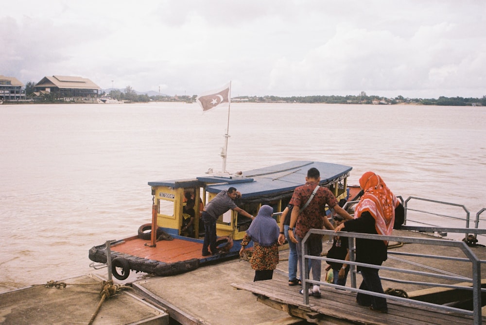 a group of people boarding a boat on a body of water