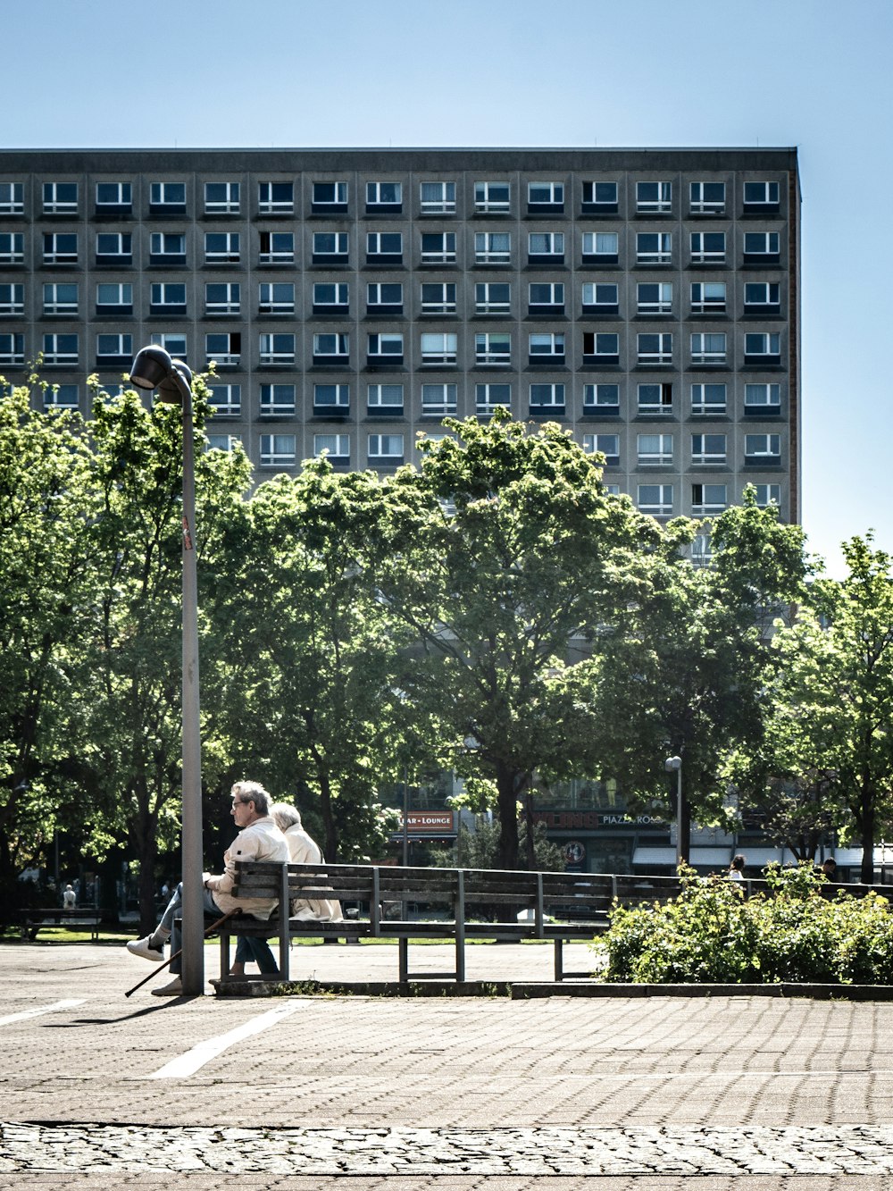 two people sitting on a bench in a park