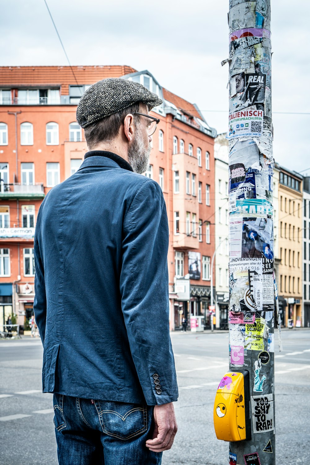 a man standing next to a pole covered in stickers