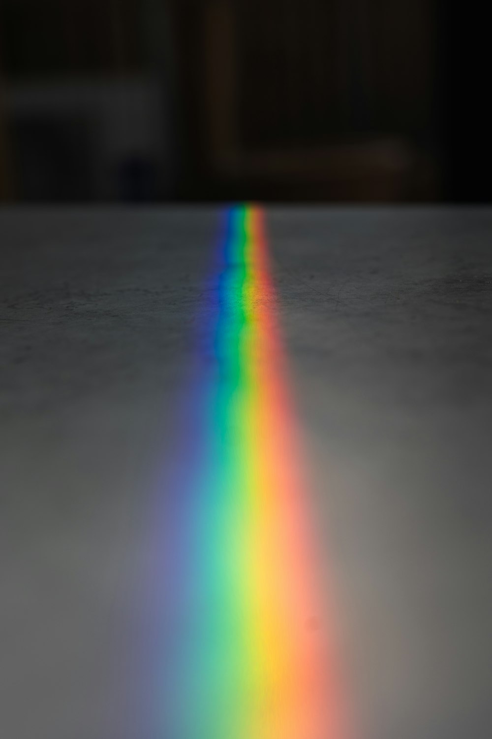 a rainbow colored object on a table with a blurry background