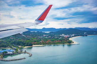 an airplane wing flying over a body of water