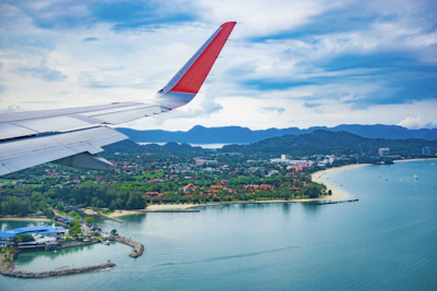 an airplane wing flying over a body of water