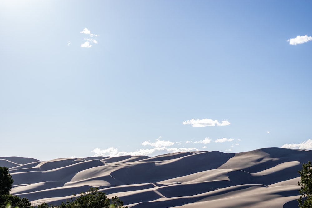 the sun is shining over a vast expanse of sand dunes