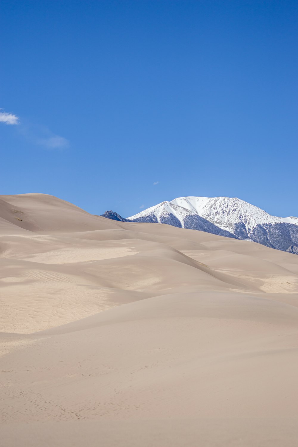 a mountain range in the distance with snow capped mountains in the distance