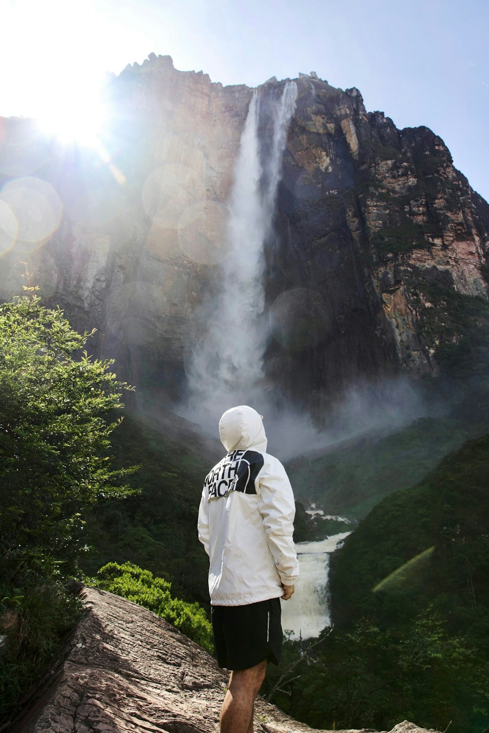 a man standing in front of a waterfall