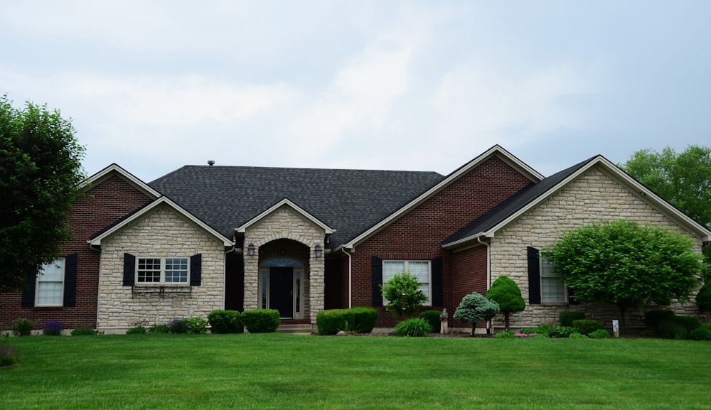 a large brick house with a green lawn