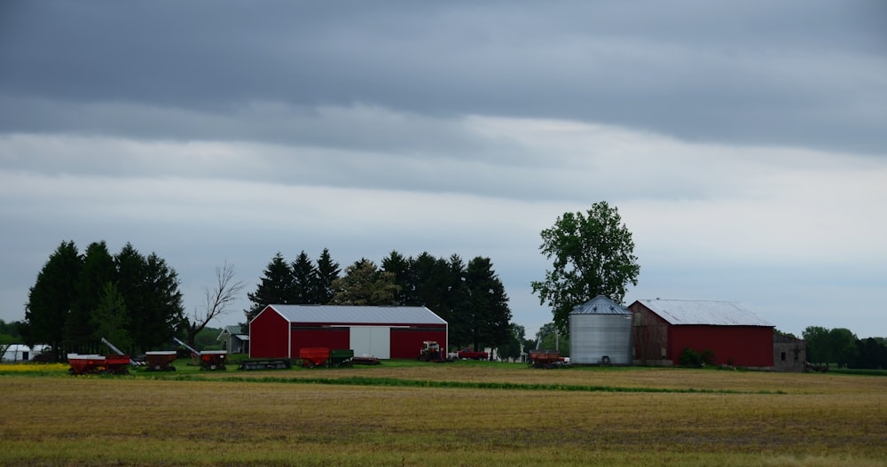 a farm with a red barn and two silos