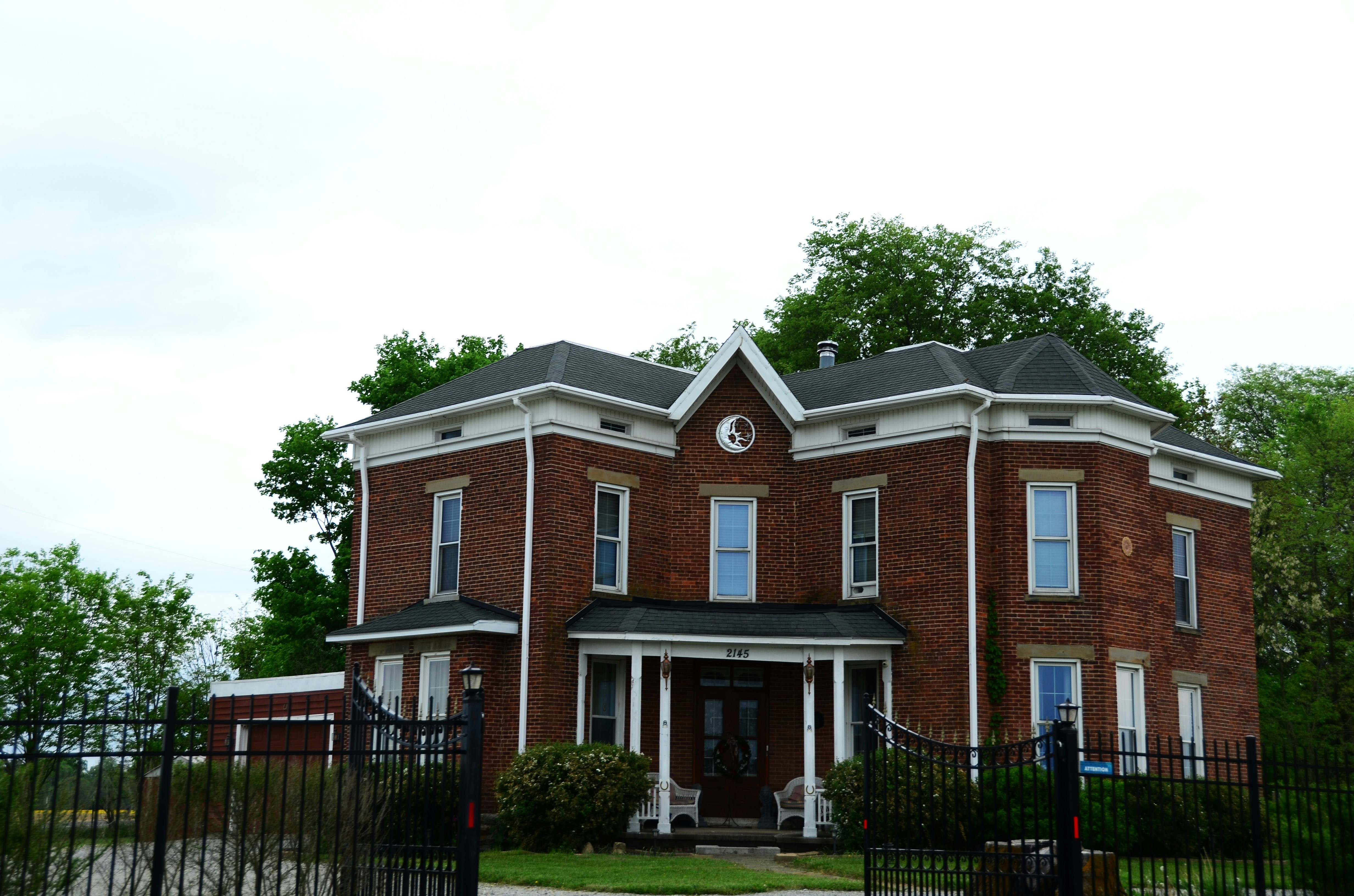 a large red brick house with a black gate