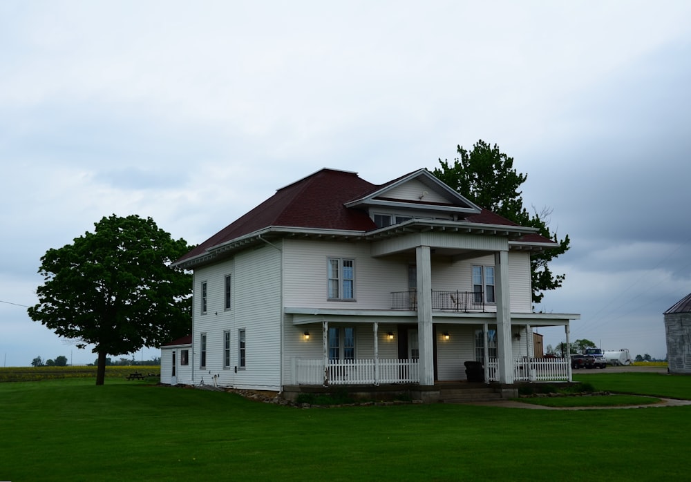 a large white house sitting on top of a lush green field