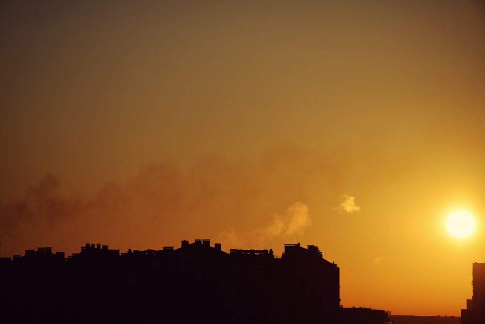 the sun is setting over a city skyline