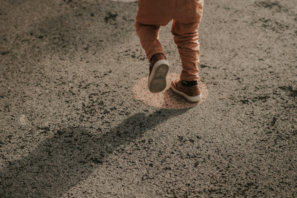 a person walking in the dirt with their shoes on