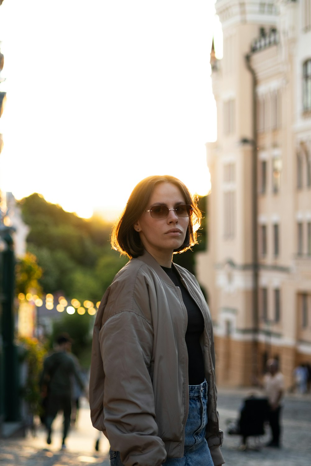 a woman standing on a sidewalk in front of a building