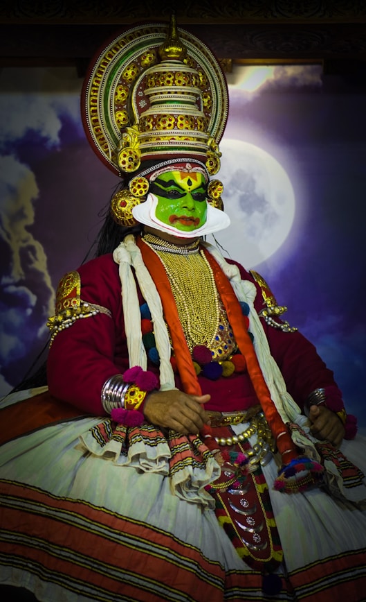 a man dressed in a costume sitting in front of a full moon