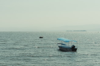 a small boat floating on top of a large body of water