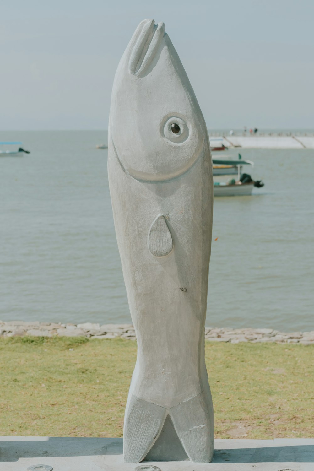 a sculpture of a fish on a beach