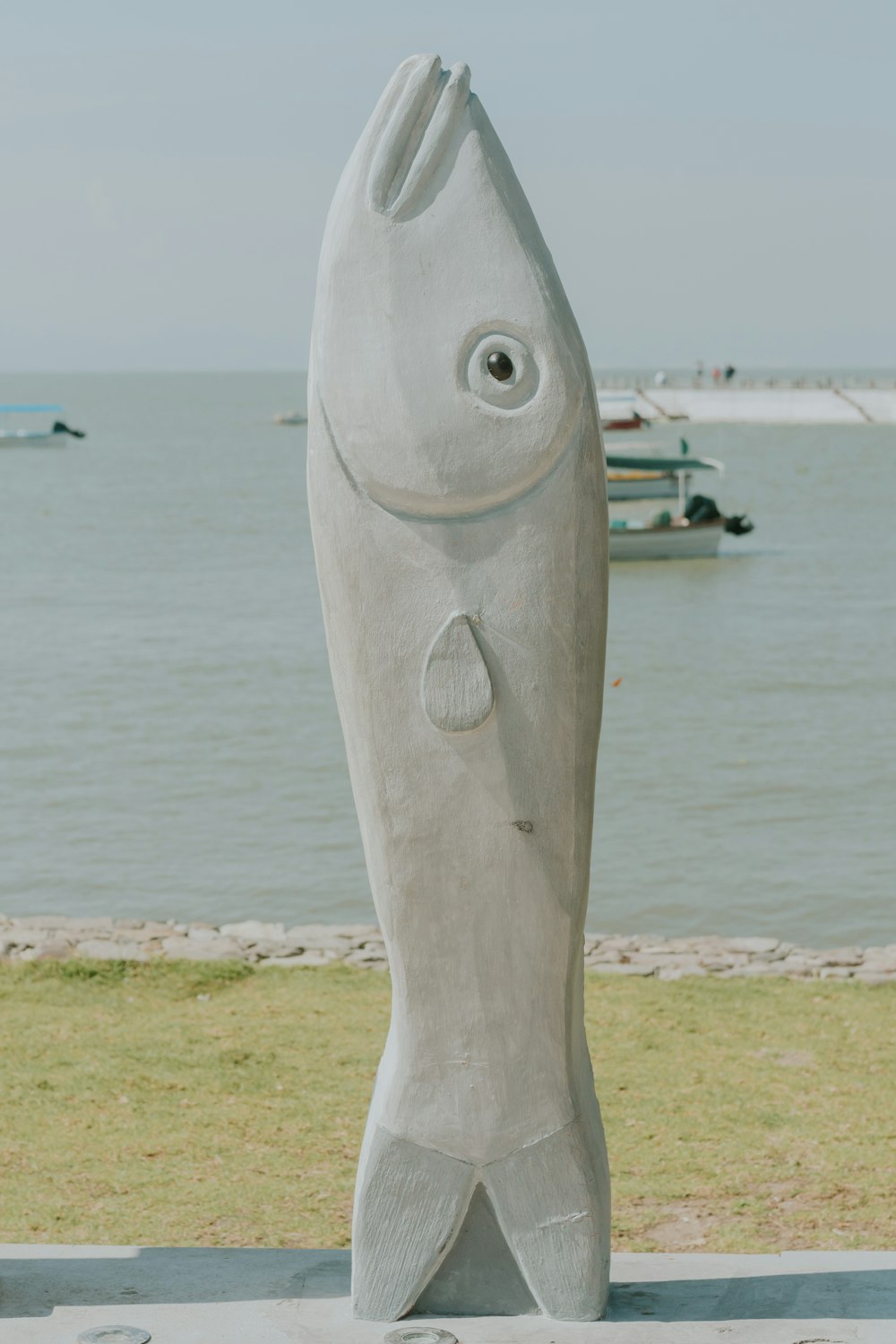 Una escultura de un pez en una playa