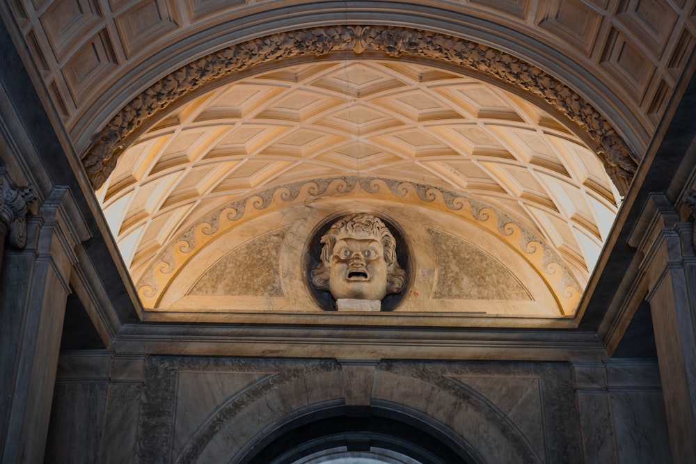 a statue of a man's head is on the wall of a building