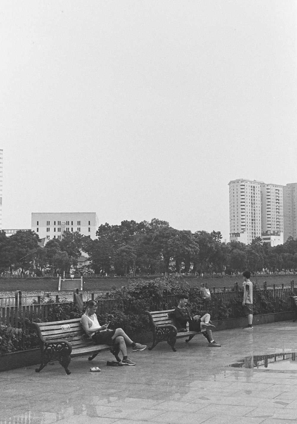 a black and white photo of people sitting on benches