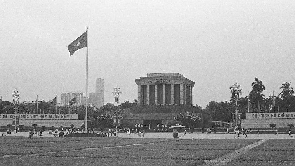 a black and white photo of a building with a flag pole