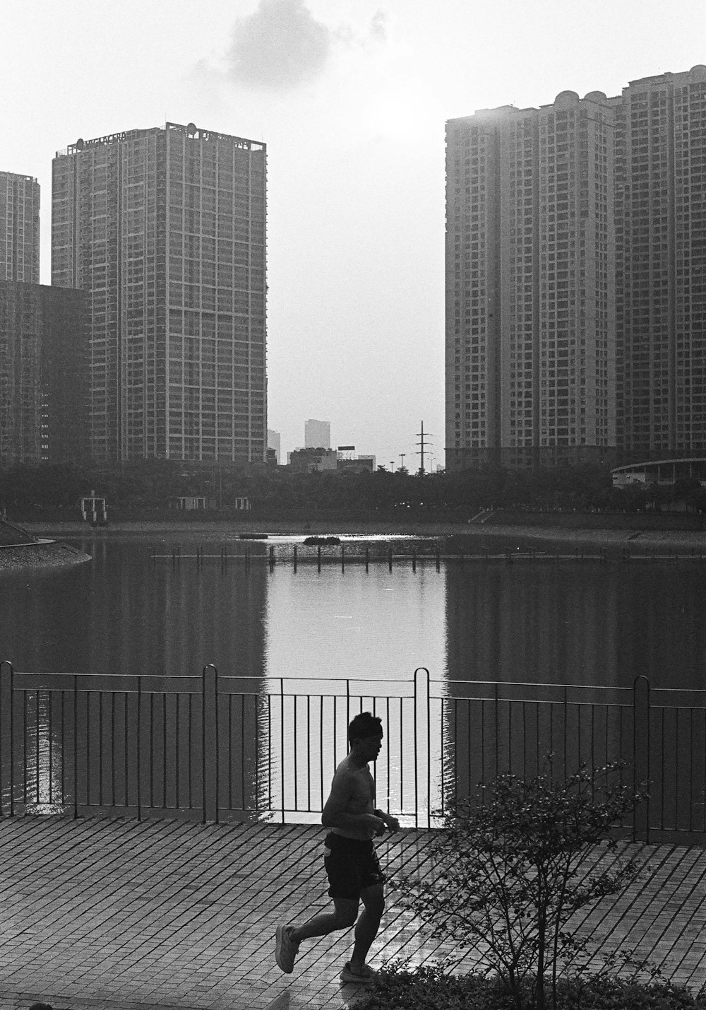 a man running down a sidewalk next to a body of water