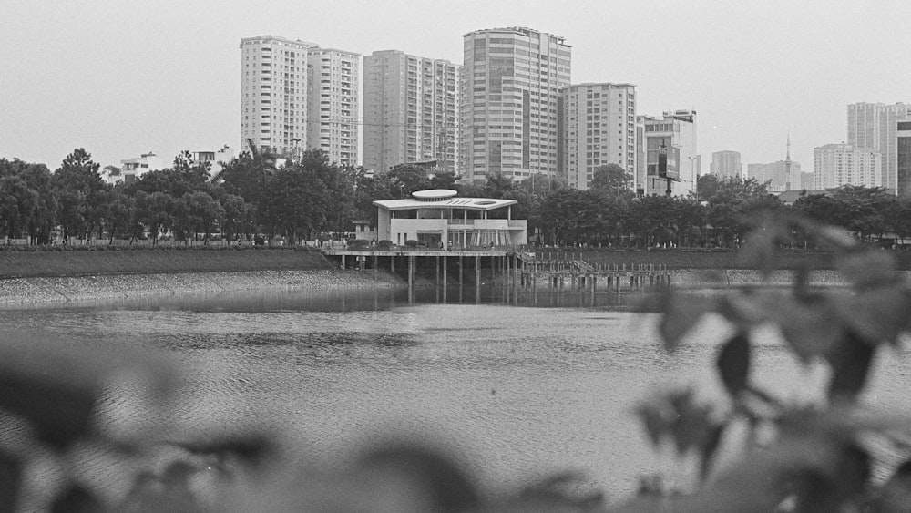 a black and white photo of a body of water with buildings in the background