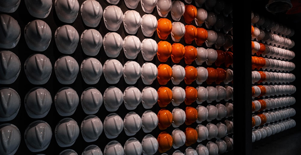 a wall of white and orange cups and saucers