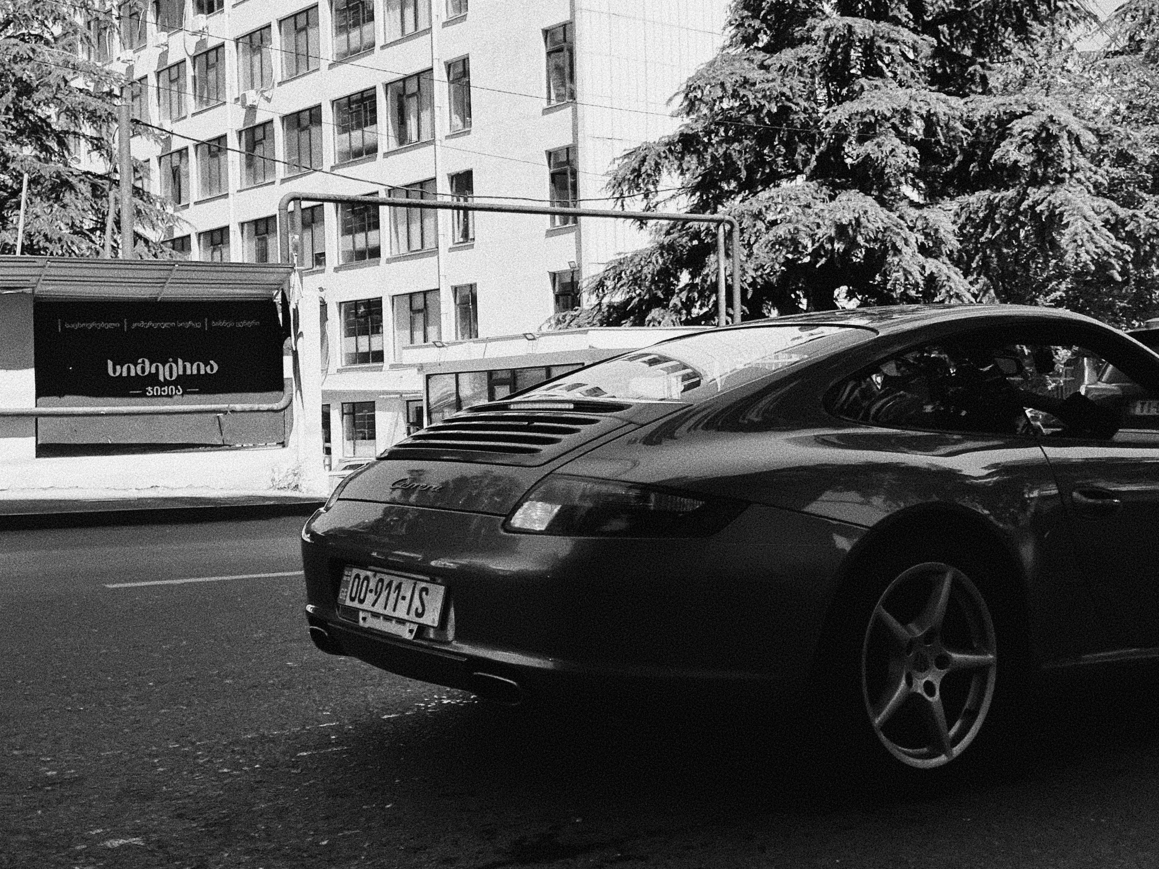 a black and white photo of a car parked on the side of the road