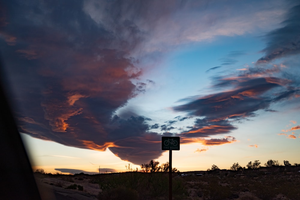 a sky filled with clouds and a street sign