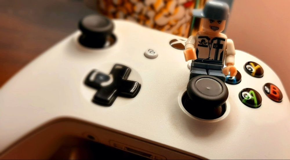 a lego man sitting on top of a white controller