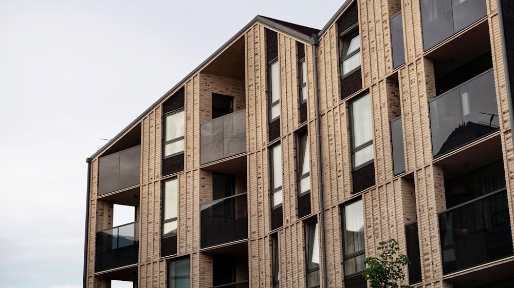 a tall building with lots of windows next to a tree