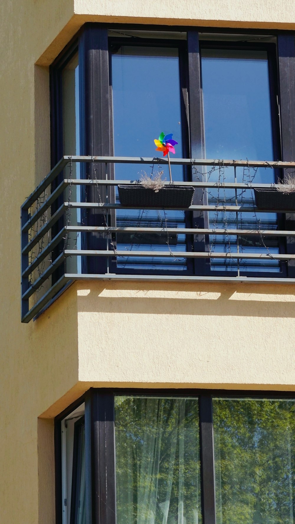 a rainbow colored kite sitting on top of a balcony