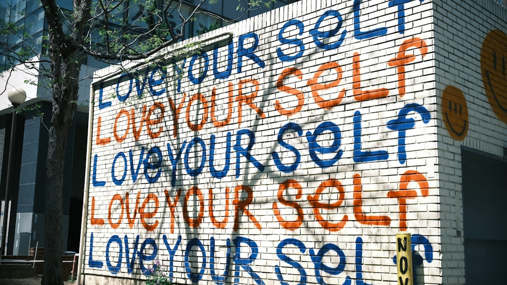 a white brick building with blue and orange writing on it