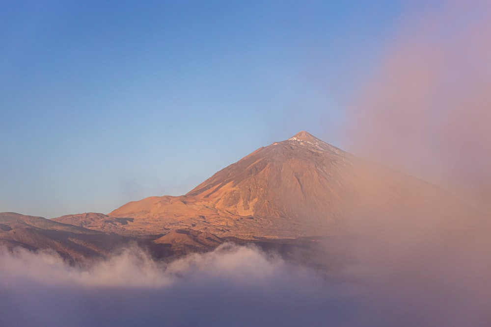 a view of a mountain covered in clouds