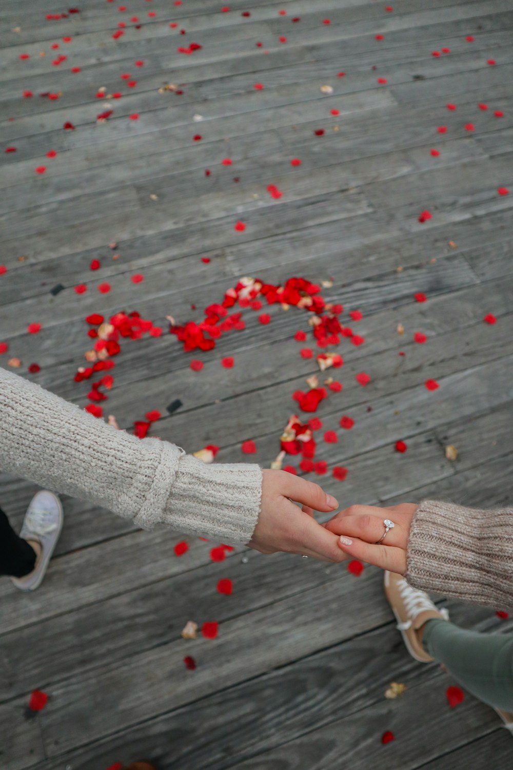 a couple of people holding hands over a wooden floor