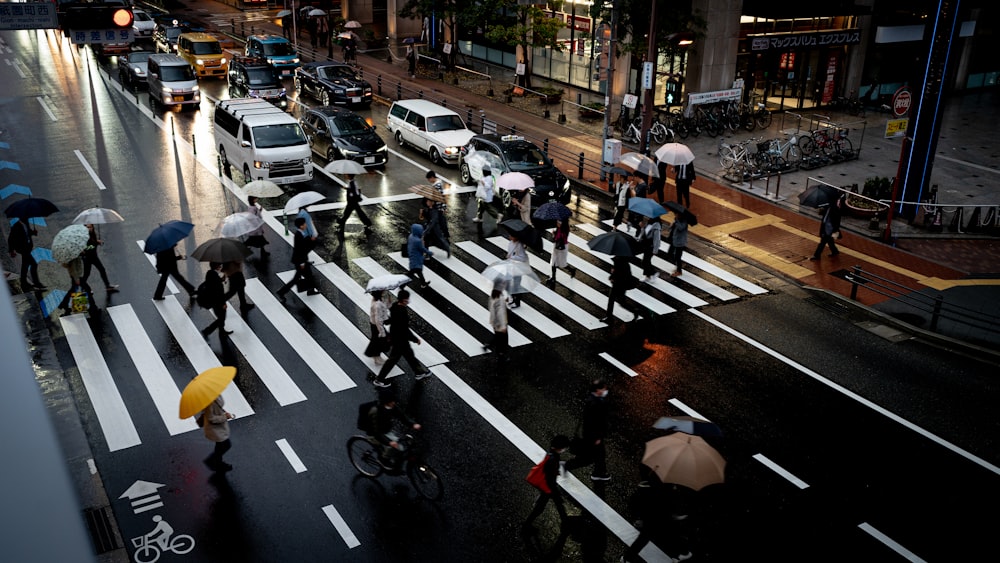 un groupe de personnes marchant dans une rue avec des parapluies