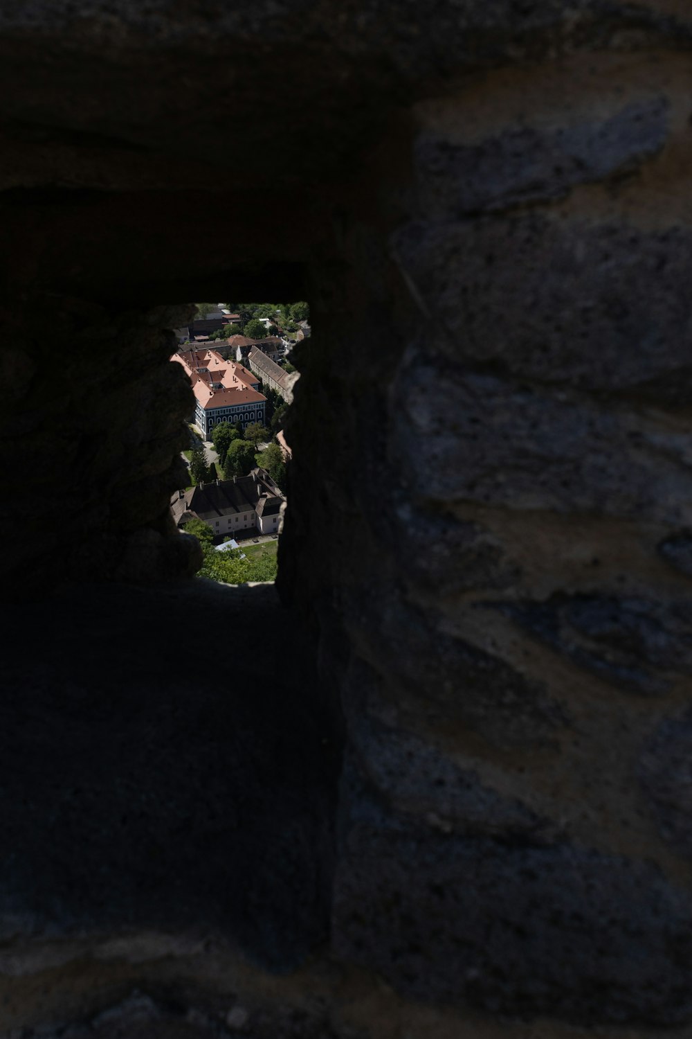 a view of a building through a stone tunnel